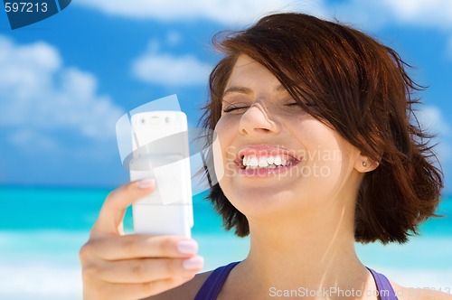 Image of happy woman with phone on the beach