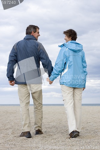 Image of Mature couple walking on a beach