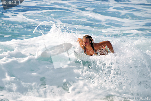 Image of Hawaii, Kauai - Oct 21, 2008: Surfer girl Malia Rimavicus comes back ashore after training amidst the foamy shorebreaks