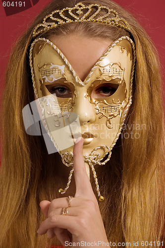 Image of young woman in mask shows gesture of silence