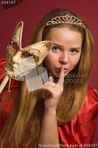 Image of beautiful girl with carnival mask shows gesture of silence