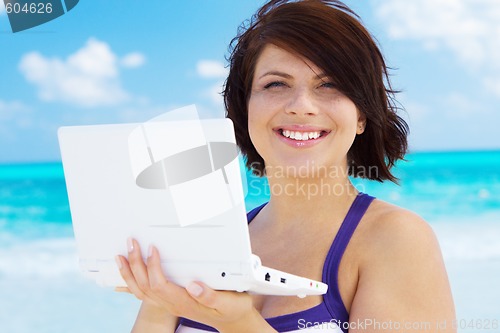 Image of woman with laptop computer on the beach