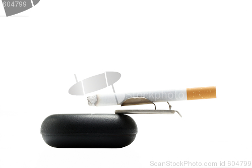 Image of Cigarette on ashtray over white