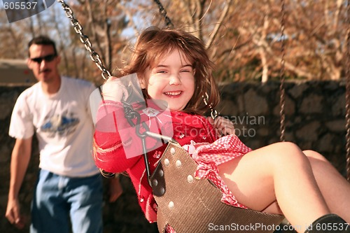 Image of Father and Daughter Swinging on the Park