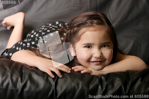 Image of Beautiful Young Child Smiling Lying on a Couch