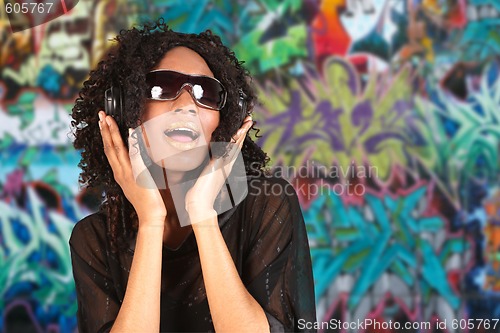 Image of Woman Listening to Music on Headphones Against  Grunge Grafitti