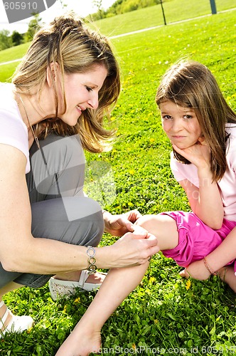 Image of Mother putting bandage on child