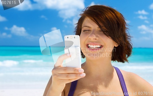 Image of happy woman with phone on the beach