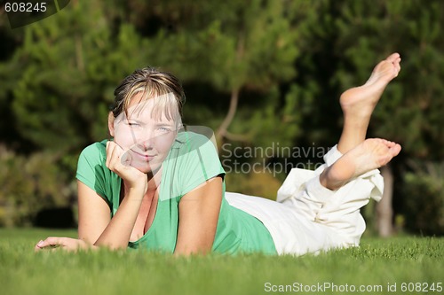 Image of Woman relaxing on a lawn with a nice defocused background