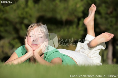 Image of Woman relaxing on a lawn with a nice defocused background