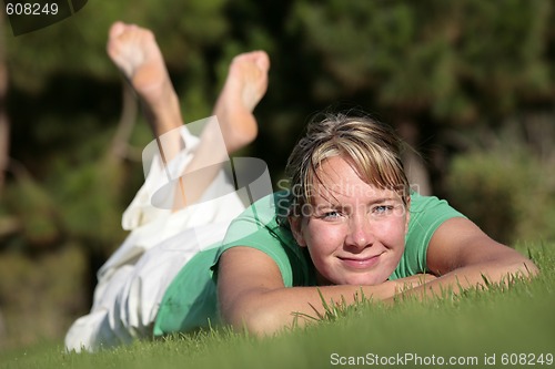 Image of Woman relaxing on a lawn with a nice defocused background