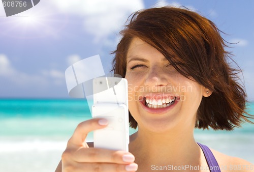 Image of happy woman with phone on the beach