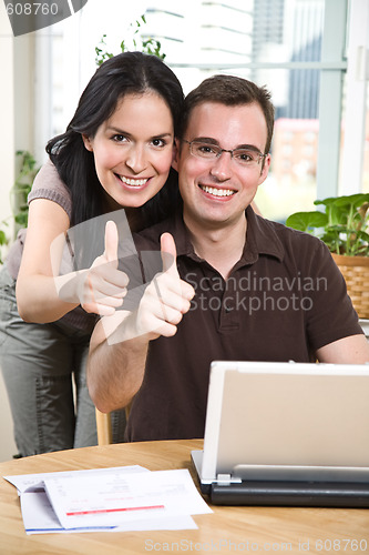 Image of Happy couple giving thumbs up 