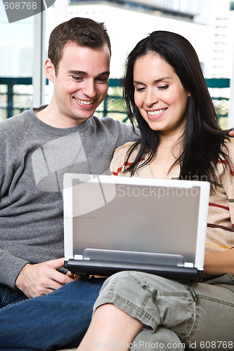 Image of Happy couple browsing internet at home