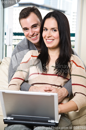 Image of Happy couple browsing internet at home