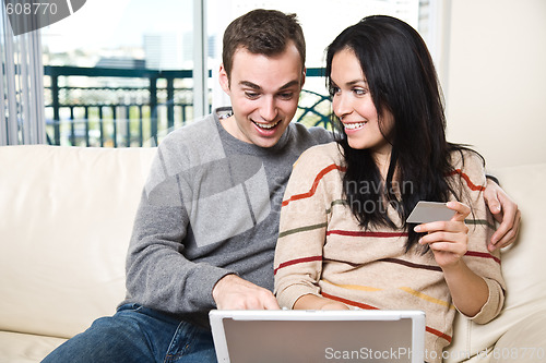 Image of Happy couple shopping online from home