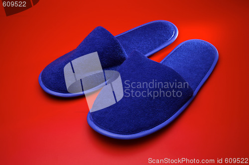 Image of Blue slippers on red background