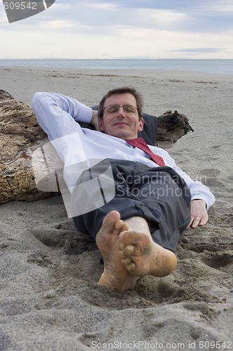 Image of Businessman sleeping on a beach