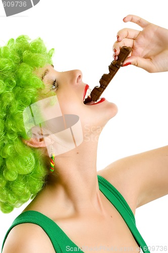 Image of closeup of an attractive woman with green wig biting a chocolate bar