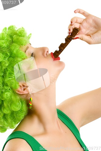 Image of closeup of an attractive woman with green wig biting a chocolate bar