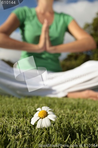 Image of Woman Meditating with Blue Sky and Daisies