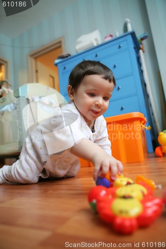 Image of infant plays on floor, soft focus
