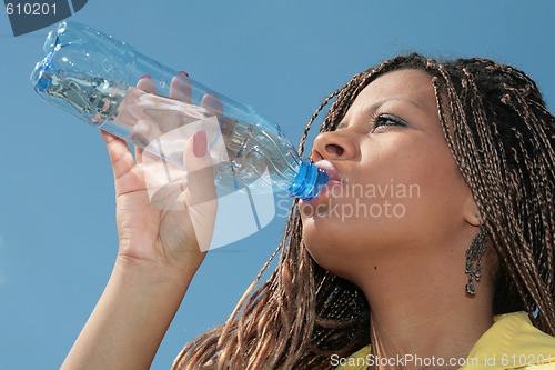 Image of black african girl drinks a water