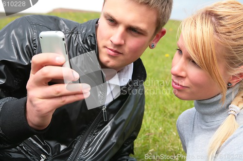 Image of guy and girl look at device
