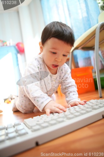 Image of baby and computer keyboard, soft focus