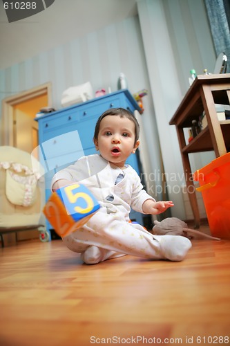 Image of adorable infant plays in the room, soft focus