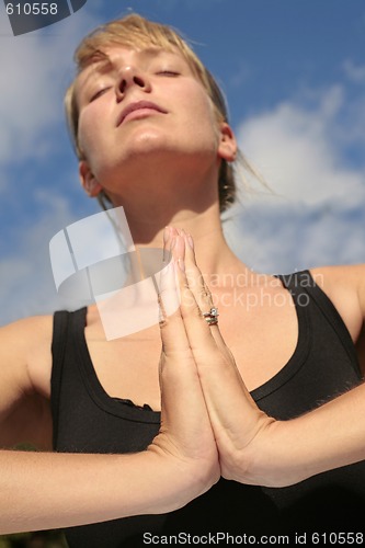 Image of Woman Meditating with Blue Sky