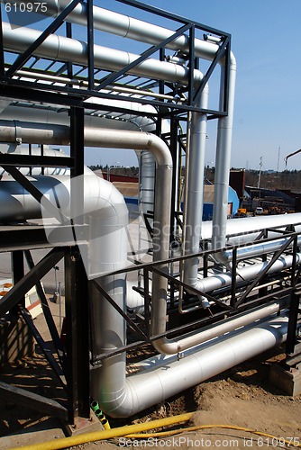 Image of industrial pipelines on pipe-bridge against blue sky