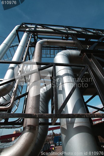 Image of industrial pipelines on pipe-bridge against blue sky