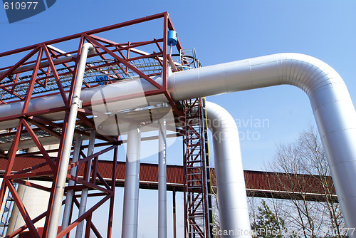 Image of industrial pipelines on pipe-bridge against blue sky  