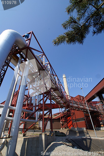 Image of industrial pipelines on pipe-bridge against blue sky  