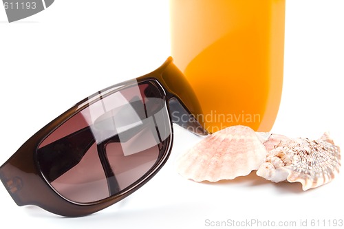 Image of sunglasses, shells and lotion