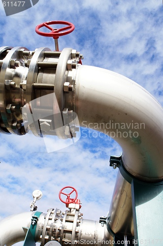 Image of industrial pipelines on pipe-bridge against blue sky