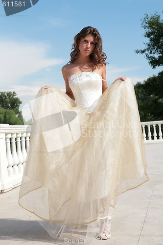 Image of attractive young woman in white-golden gown