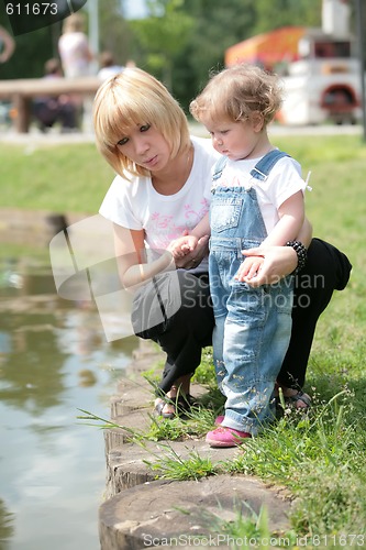 Image of mother and small daughter near water