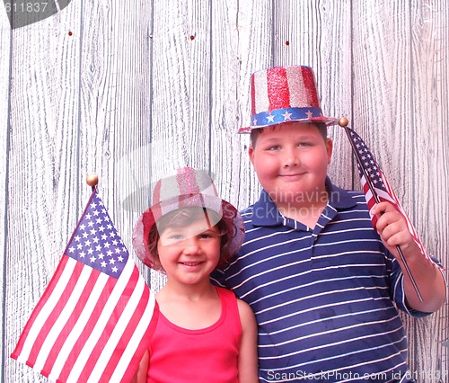Image of Young boy and girl with 4th of july hats on