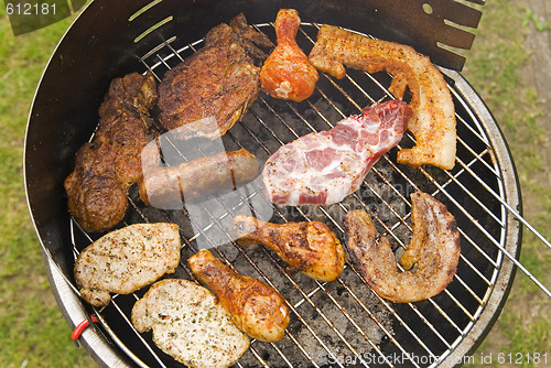 Image of Sausages, beef and other meat on a barbecue