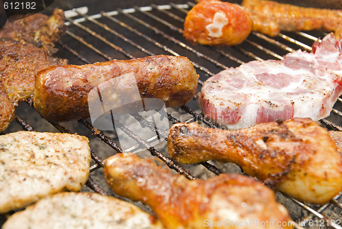 Image of Sausages, beef and other meat on a barbecue