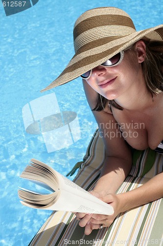 Image of Woman in Sunhat Reading by Pool