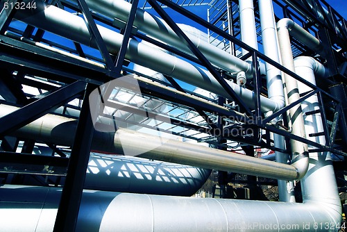 Image of industrial pipelines on pipe-bridge against blue sky