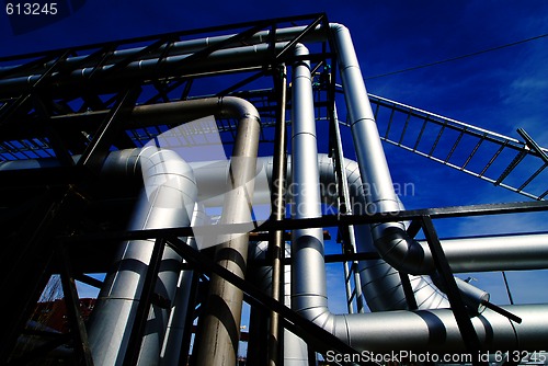 Image of industrial pipelines on pipe-bridge against blue sky