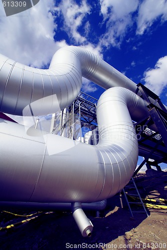 Image of industrial pipelines on pipe-bridge against blue sky