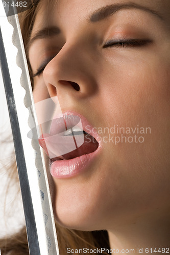 Image of Beautiful girl licks cutting edge