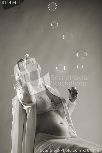 Image of pregnant woman blows bubbles