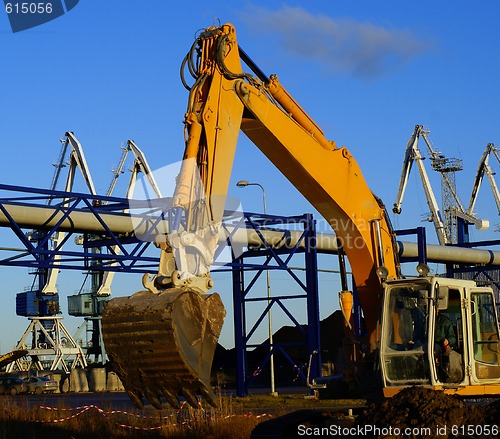 Image of Hydraulic excavator at work. Shovel bucket against blue sky