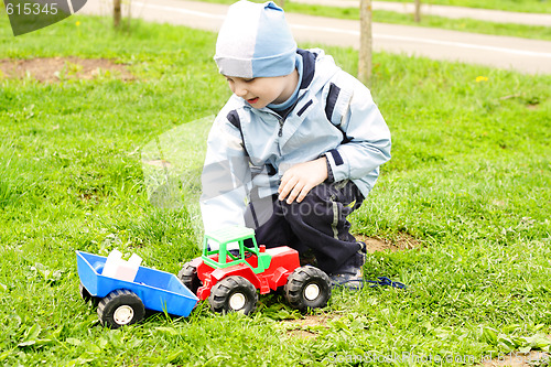 Image of Boy playing with toy tractor